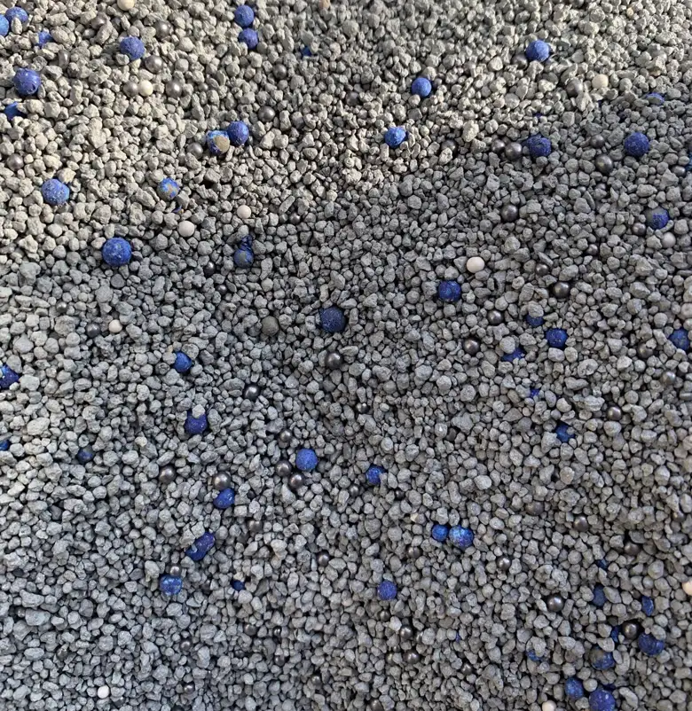 Premium bentonite cat litter granules with visible mixed mineral particles
