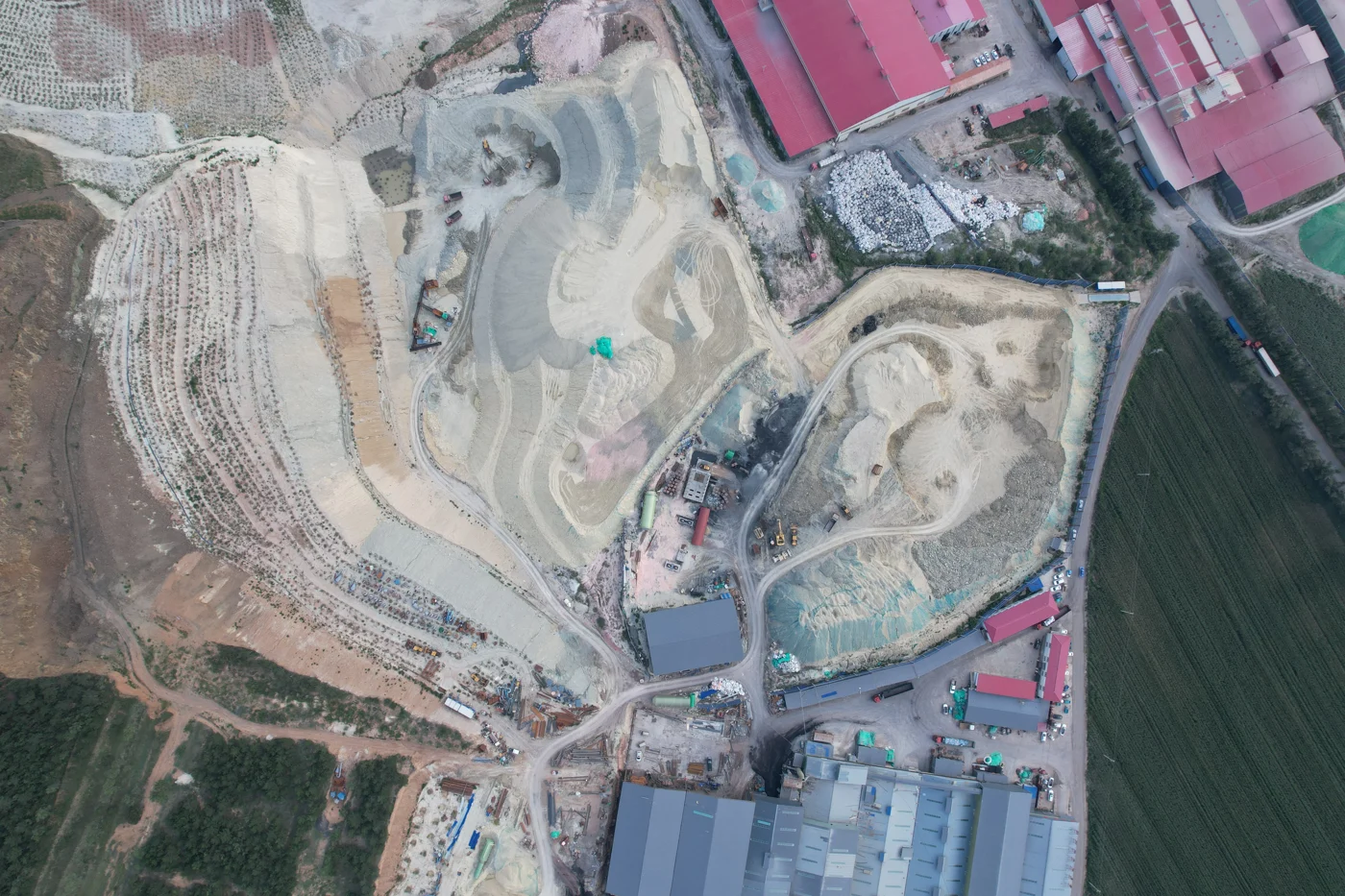 Aerial view of the mineral excavation area and buildings at the LINGSHUAI raw material site